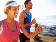 Picture of a smiling couple running on the beach.